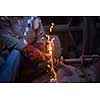 the blacksmith polishing metal products making sparks while using a grinding machine in his traditional workshop