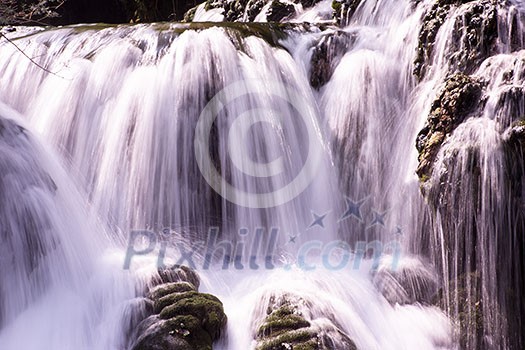 Amazing nature landscape, beautiful waterfall with sunlight in deep summer forest Amazing nature landscape, beautiful waterfall with sunlight in deep summer forest