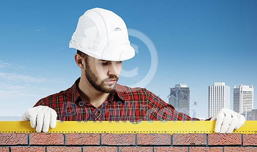 Builder man in checked shirt using measuring level Builder man in checked shirt using measuring level