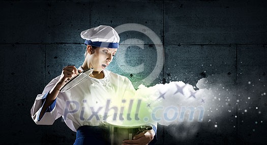 Pretty woman cook in hat and apron with pot in hands