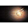 Power and energy concept with glass light bulb on brick wall