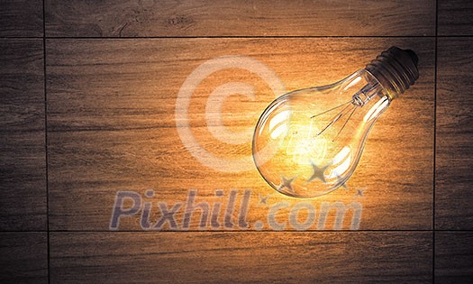 Power and energy concept with light bulb on wooden surface Power and energy concept with light bulb on wooden surface
