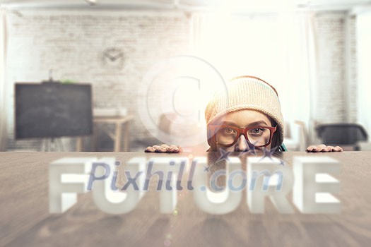 Attractive student girl in red glasses peeping from under table