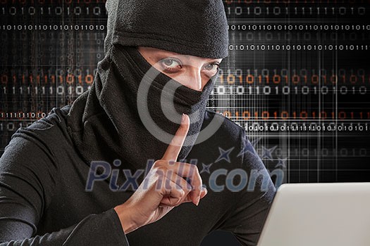 Hacker woman in dark clothes using laptop against digital background