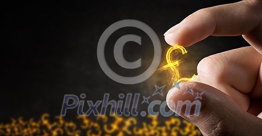 Tiny pound currency sign holden between fingers Tiny pound currency sign holden between fingers