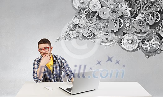 Young pensive guy in red glasses surfing the Internet Young pensive guy in red glasses surfing the Internet