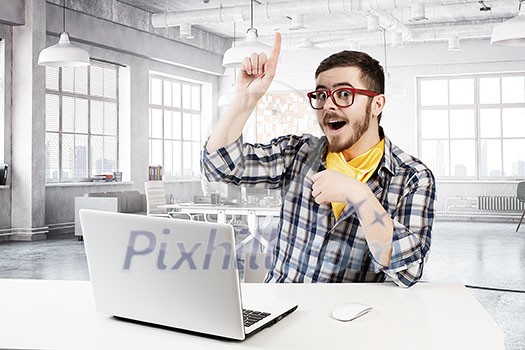 Young emotional guy in red glasses surfing the Internet