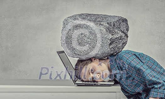 Woman programmer pressed with heavy stone to laptop Woman programmer pressed with heavy stone to laptop