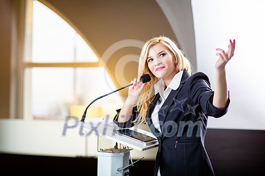 Pretty, young business woman giving a presentation in a conference/meeting setting (shallow DOF; color toned image)