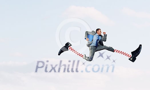 Businessman in suit running with big springs on feet