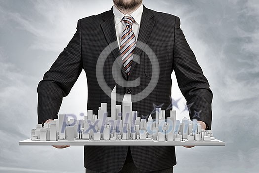 Young businessman presenting model of construction project Young businessman presenting model of construction project