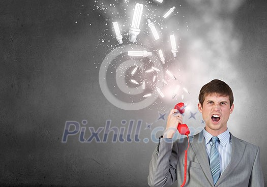 Handsome businessman talking on red phone handset Handsome businessman talking on red phone handset