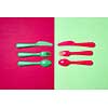 Multicolored set of plastic tableware on a duotone background with copy space. Top view.