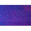 Neon painted water drops on purple and blue colored background. Trendy backdrop for your design.