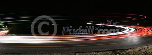 vegicle light trails in night on busy countryroad curve  long exposure