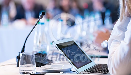 close up shot of business people hands typing on laptop computer keyboard during the business seminar at big modern conference room