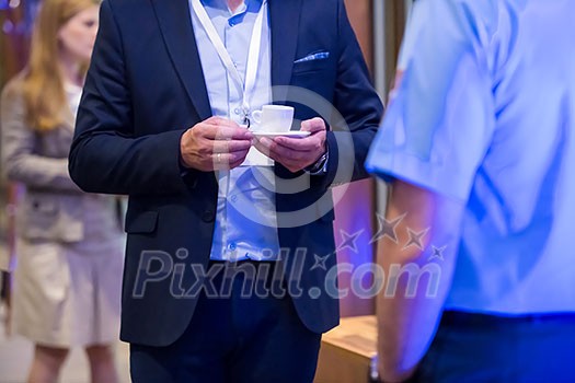 Close up of man hands in a business suit holding a cup of coffee during a business seminar break