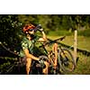 Young man biking on a mountain bike enjoying healthy active lifestyle outdoors in summer (shallow DOF