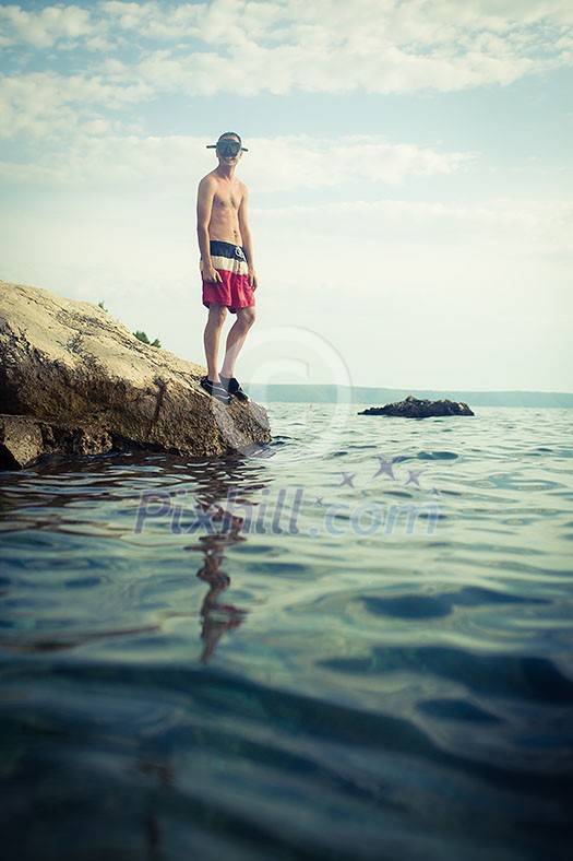 Young man having fun and taking a dive in the sea