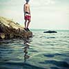 Young man having fun and taking a dive in the sea