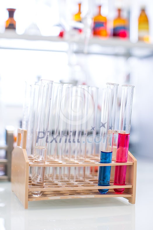 Lab worker's hands while at work at a research center in a lab, carrying out an experiment (shallow DOF; color toned image)