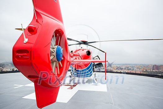 Modern medical helicopter on a hospital rooftop helipad from behind - shallow DOF Modern medical helicopter on a hospital rooftop helipad from behind - shallow DOF