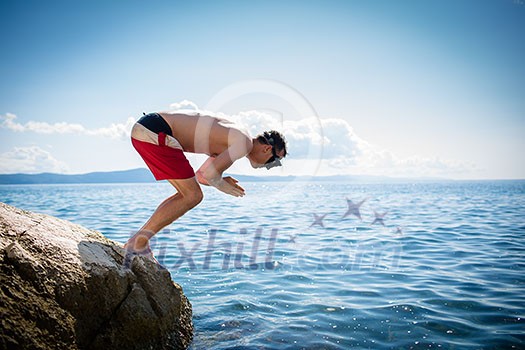 Young man having fun and taking a dive in the sea