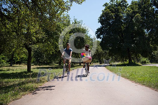 a young man and a beautiful African American girl enjoying a bike ride in nature on a sunny summer day a young man and a beautiful African American girl enjoying a bike ride in nature on a sunny summer day