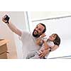 young father and his son photographed themselves with cardboard boxes around them while moving into their new home