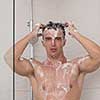 young good looking and attractive man with muscular body wet taking shower in bath