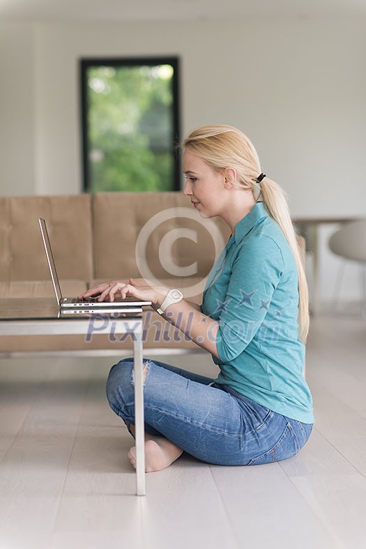 beautiful young women using laptop computer on the floor of her luxury home