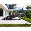 young handsome man doing morning yoga exercises in front of his luxury home villa