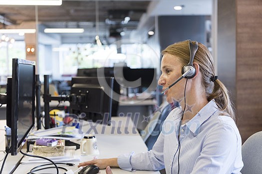 female customer support phone operator with headset  at workplace