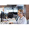 female customer support phone operator with headset  at workplace