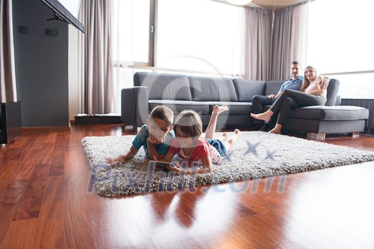 Happy Young Family Playing Together at home.kids using tablet on the floor Happy Young Family Playing Together at home.kids using tablet on the floor