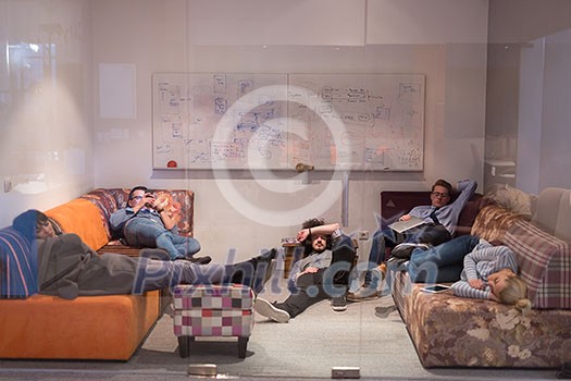 group of young casual software developer sleeping on  sofa during a work break in creative startup office