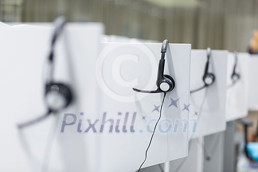 Headphones hanging on cubicle partition in empty call center office