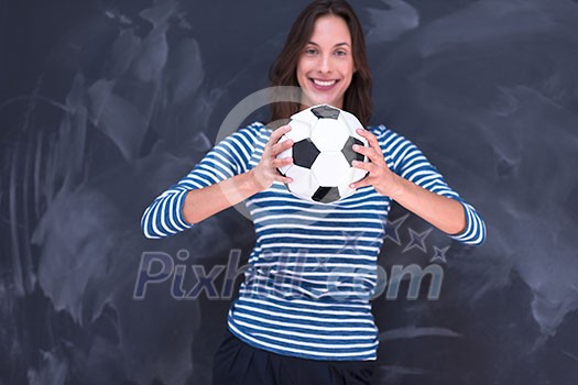 portrait of a young woman holding a soccer ball in front of chalk drawing board portrait of a young woman holding a soccer ball in front of chalk drawing board