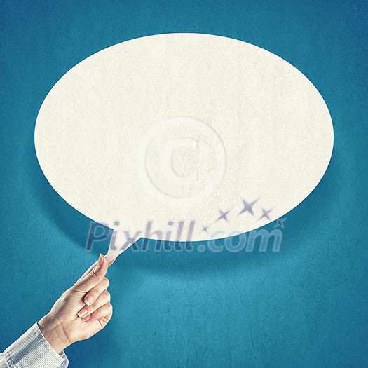 Hand holding an empty speech bubble on blue background Hand holding an empty speech bubble on blue background