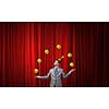 Young businessman in cap on stage juggling with balls
