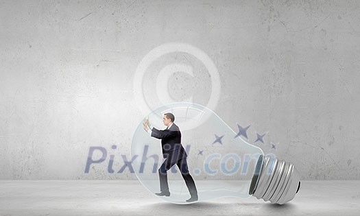 Businessman inside light bulb trying to get out Businessman inside light bulb trying to get out