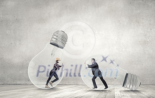Businesswoman and businessman inside light bulb trying to get out Businesswoman and businessman inside light bulb trying to get out