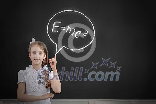 School girl at blackboard pointing at science formula with finger School girl at blackboard pointing at science formula with finger