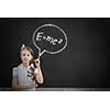 School girl at blackboard pointing at science formula with finger