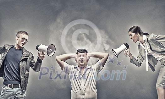 Furious people screaming agressively in megaphone at man Furious people screaming agressively in megaphone at man