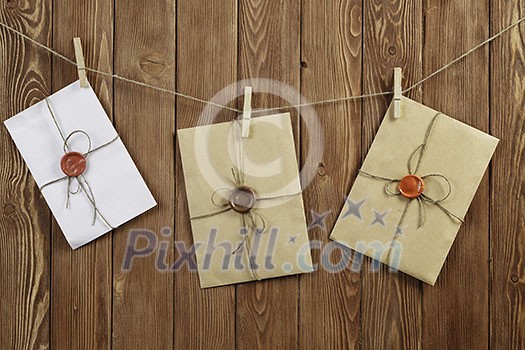 Envelopes hanging on rope on wooden background