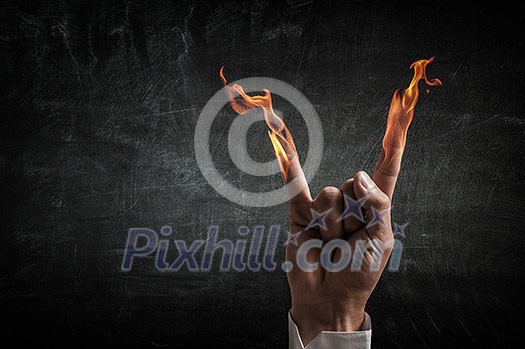 Young businessman holding fire flames in palm Young businessman holding fire flames in palm