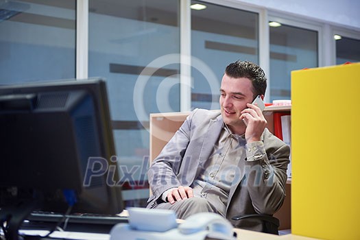 young business man working on computer and talking by phone on modern office indoors young business man working on computer and talking by phone on modern office indoors
