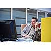 young business man working on computer and talking by phone on modern office indoors