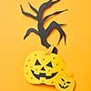 Handcraft paper tree and scary pumpkins on an orange background with space for text. Creative layout for Halloween. Flat lay